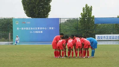多名红衣球员在球场上围成一圈。